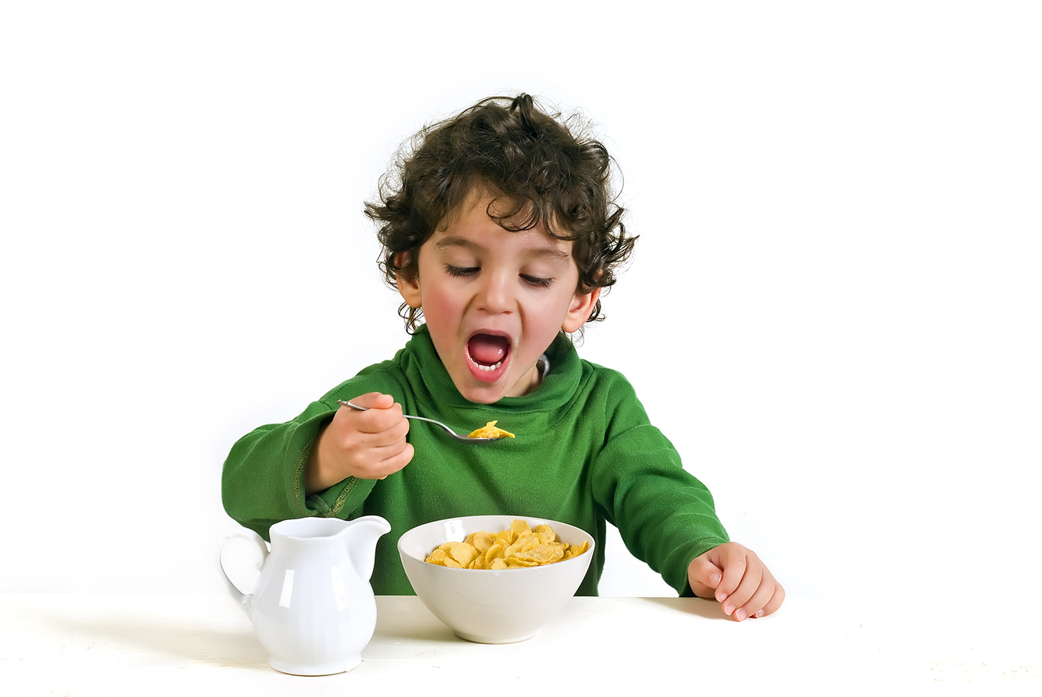 young boy eating cereals isolated on white
